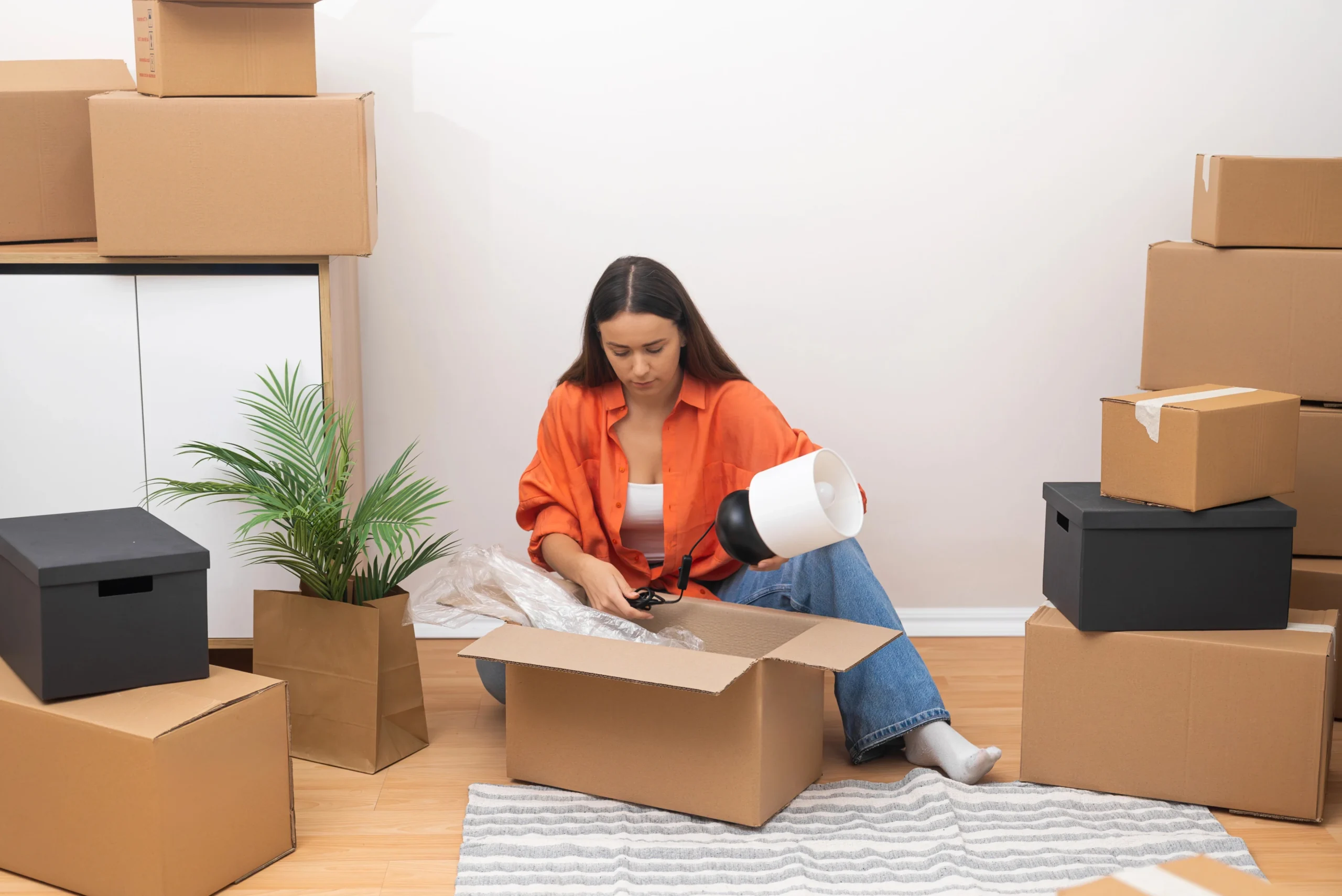 Woman Unpacking In A Bright New Home Surrounded By Boxes, Movers And Packers Perth